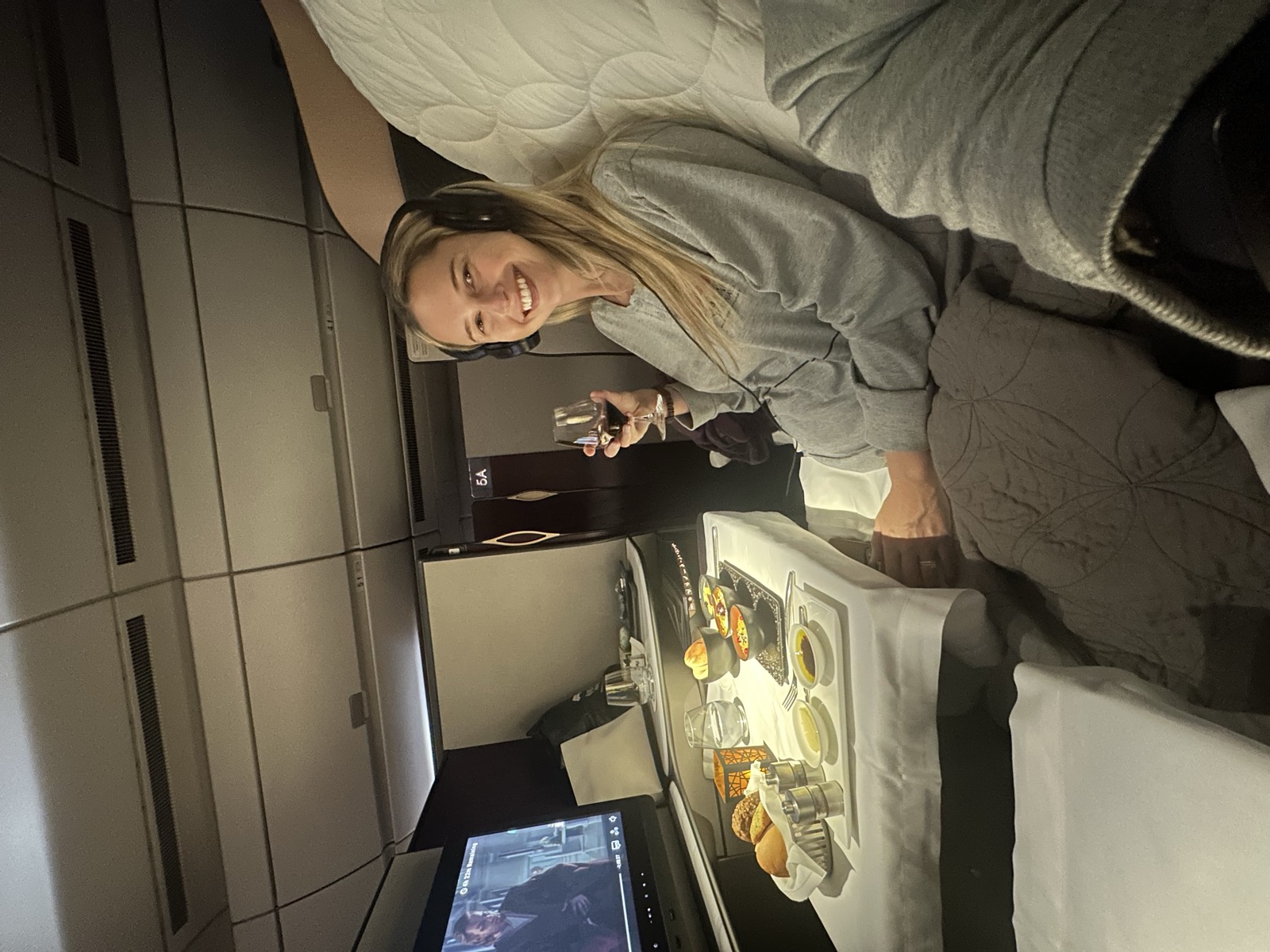 Christie relaxing with a meal and a glass of wine in her spacious business-class seat