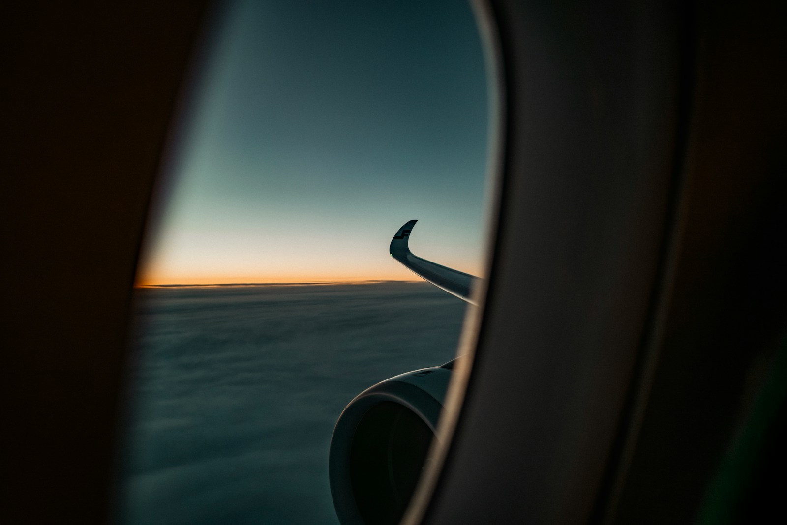 Wing over clouds at sunset, seen from a premium-cabin window